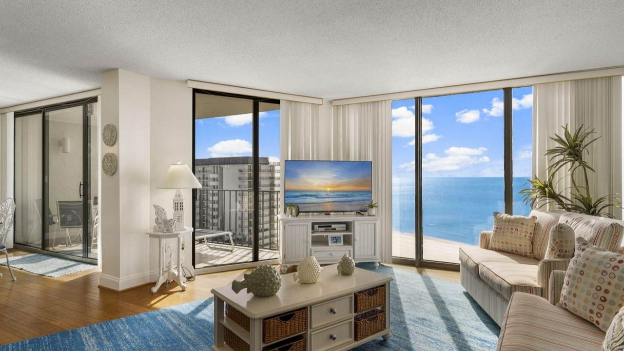the living room of an edgewater home with a view of the beach outside the window
