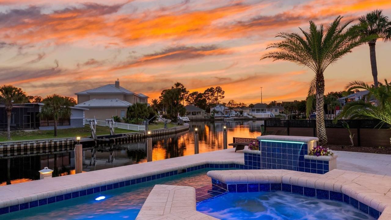 stunning sunset with a pool and hot tub in the back of a panama city beach home