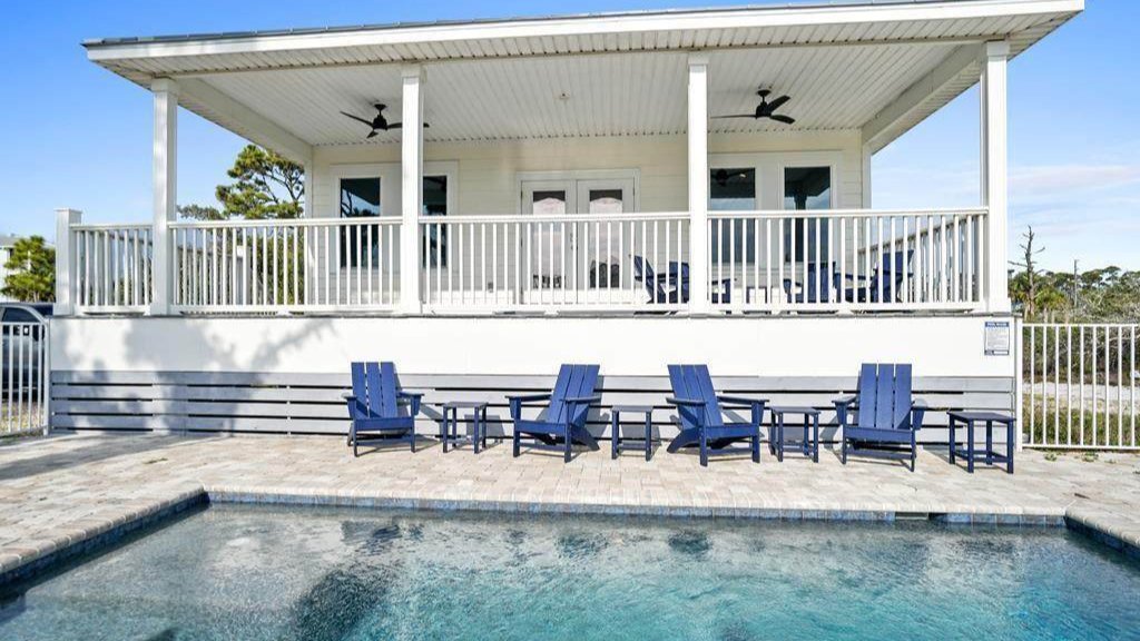view of one story cape san blas home from the backyard and its pool