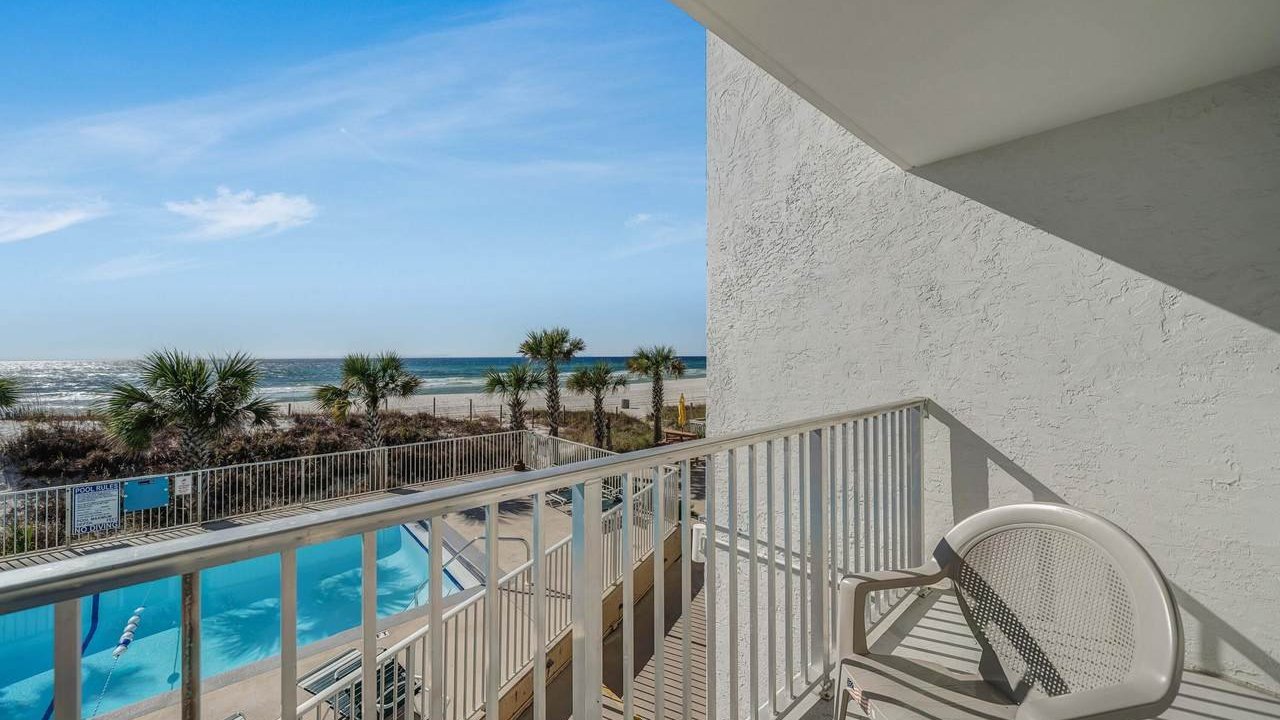 the pool at ambassador condos with a view of the beach in the background