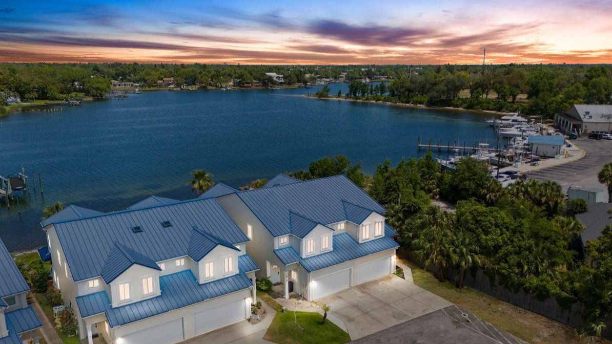 2 double story, blue-roofed callaway homes alongside a body of water[
