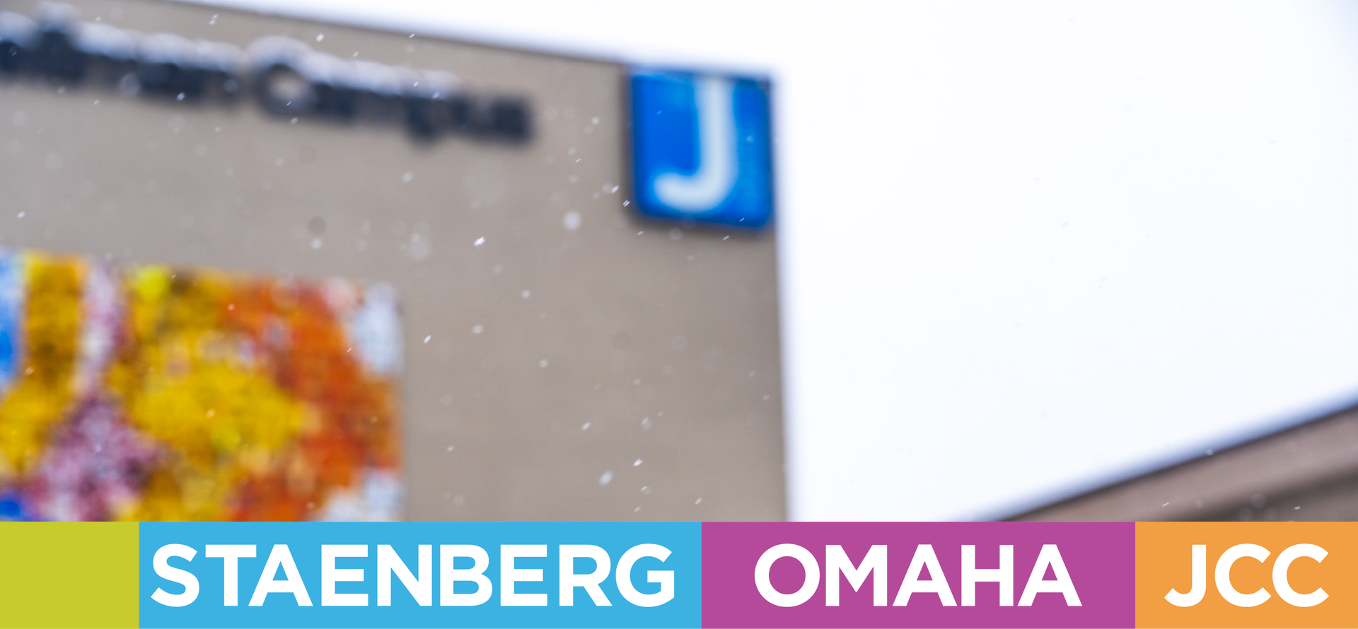 Header image of snow falling in front of the JCC main entrance.