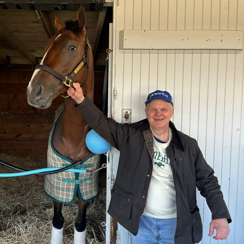 Alumnus Keith Mason stands with race horse Dornoch