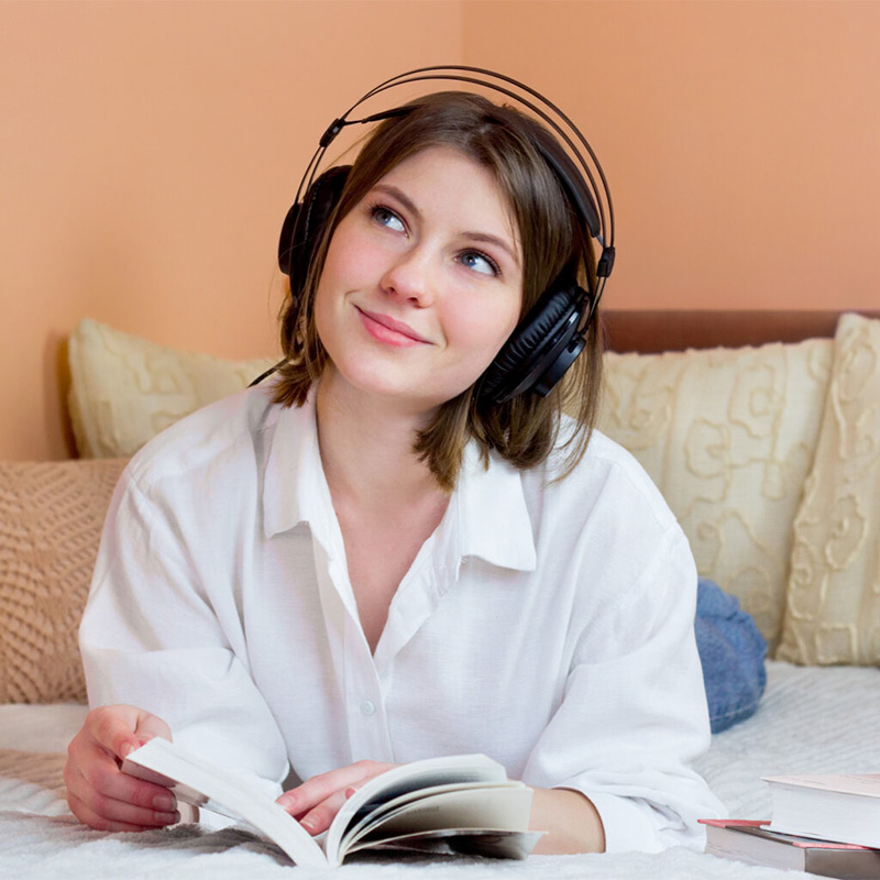 A young woman reads and listens to a podcast