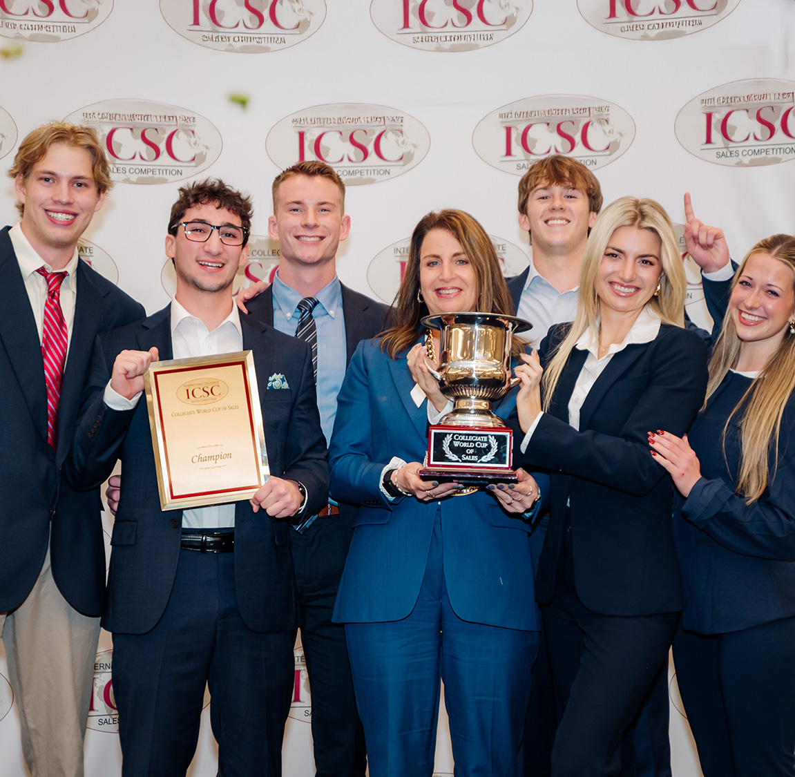 Cindy Rippe holds the world cup of sales with her sales team behind her