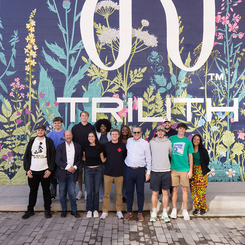 Students standing in front of a Trilith Studios mural