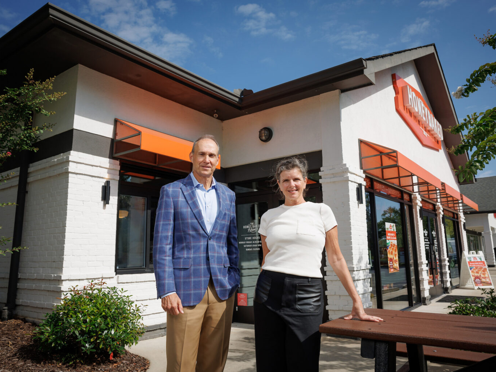 Jim Dinkins and Linda van Rees pose in front of Honey Baked Ham store