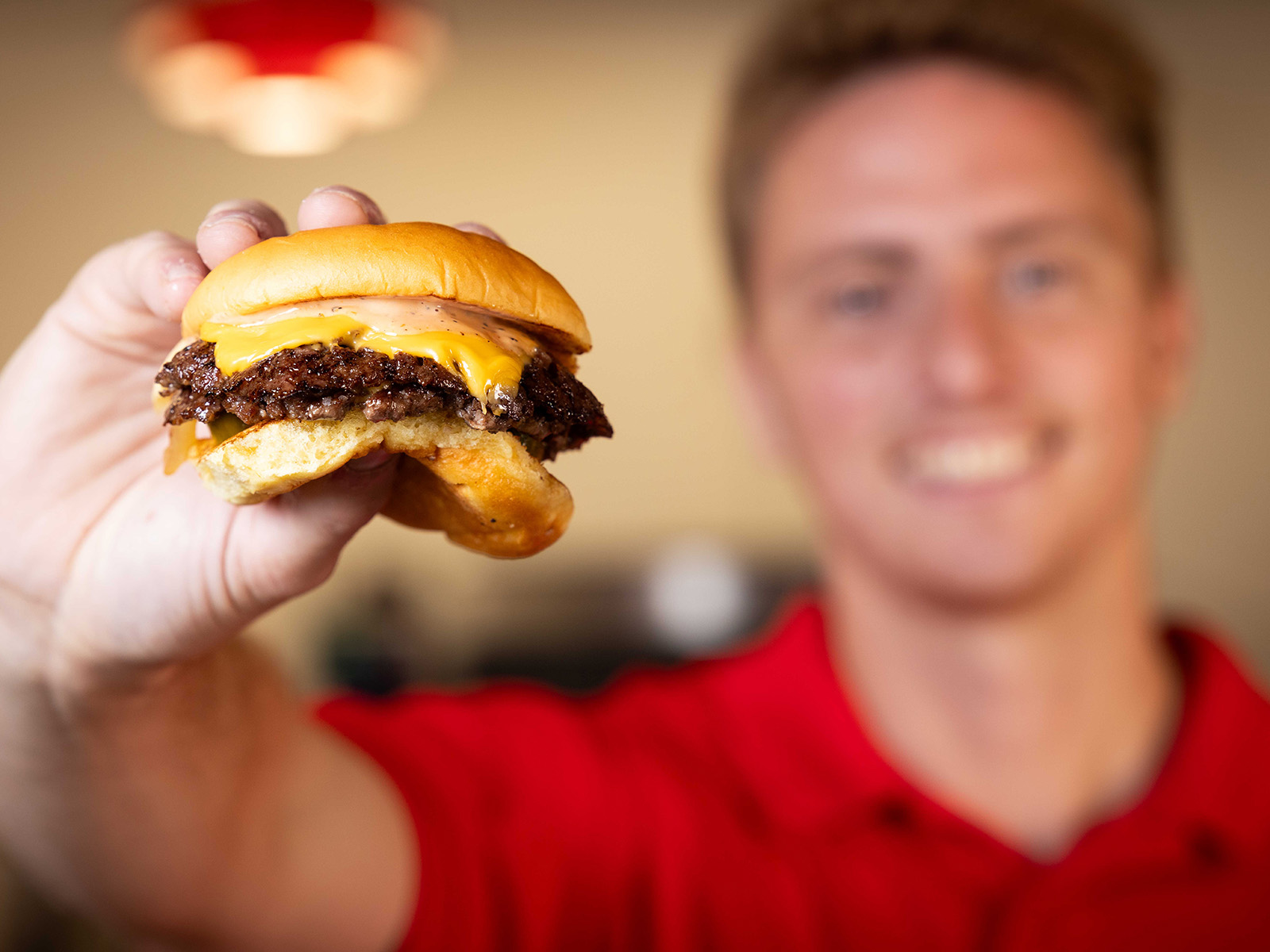 Joe Nedza holds a burger in front of himself