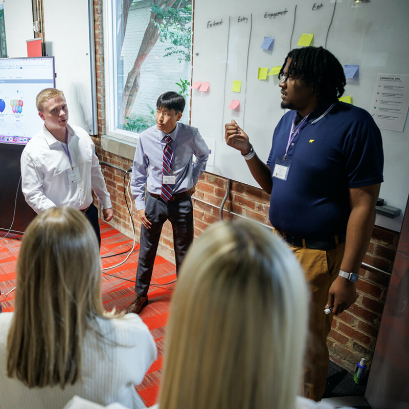 Students brainstorm at a white board during 