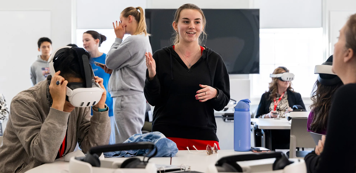 Active learning and virtual reality classroom student assistant Lilly Graves, center, guides Active Learning Summit participants through VR software during the tour of the Creative Engagement Wing. (Photo by Dorothy Kozlowski/UGA)