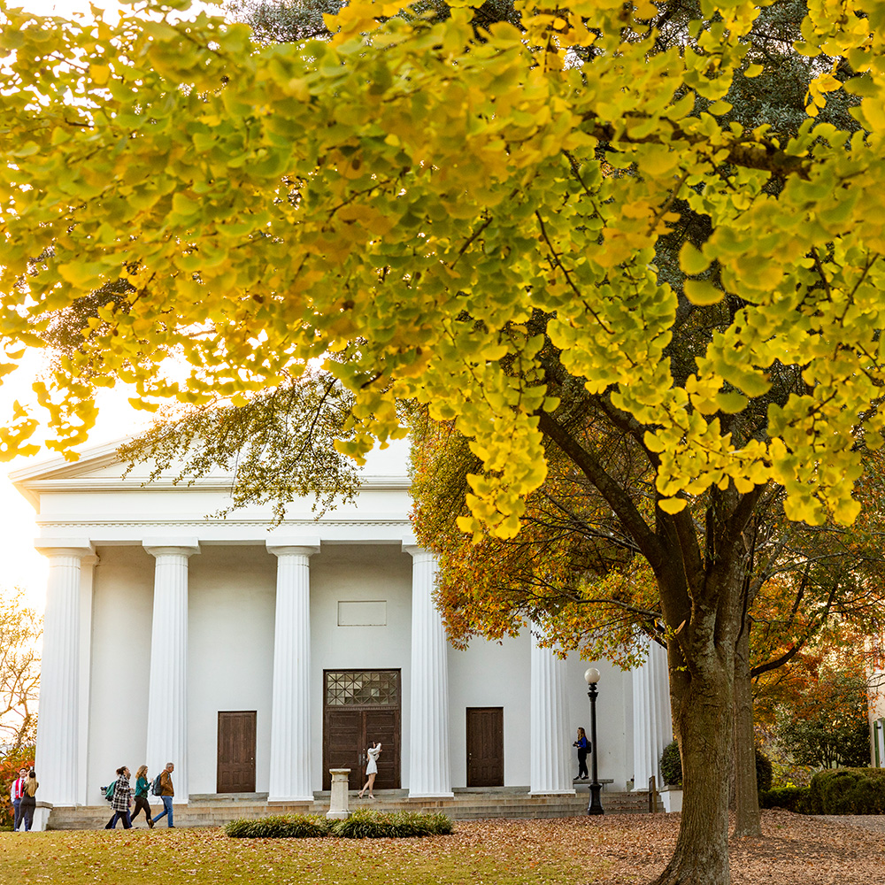 View of the Chapel surrounded by trees full of colorful fall leaves with the North Campus Quadrangle in the foreground.