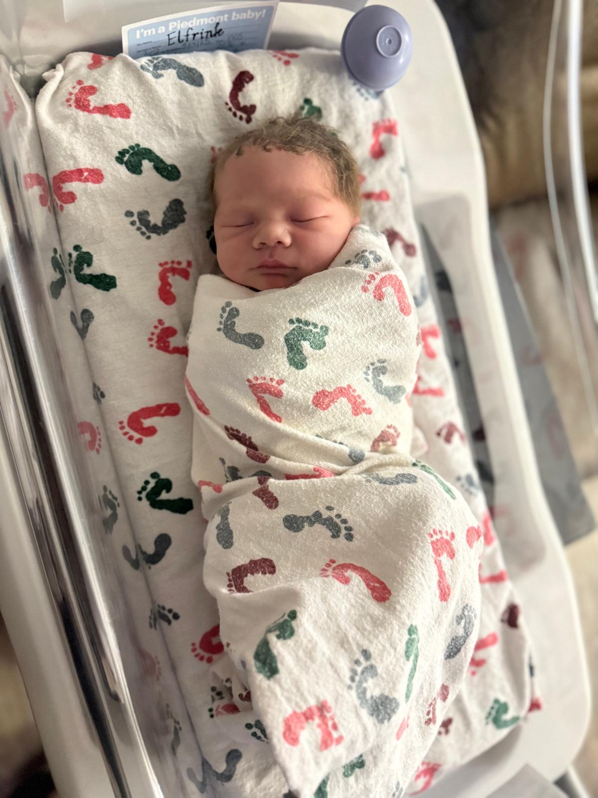 A newborn baby boy swaddled in a blanket