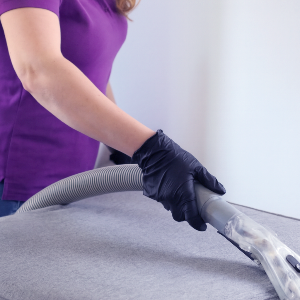 Close-up of expert cleaner using advanced upholstery cleaning tool on a gray couch — showcasing powerful stain and allergen removal for a healthier home in the Greater Orlando Metro area Close-up of expert cleaner using advanced upholstery cleaning tool on a gray couch — showcasing powerful stain and allergen removal for a healthier home in the Greater Orlando Metro area