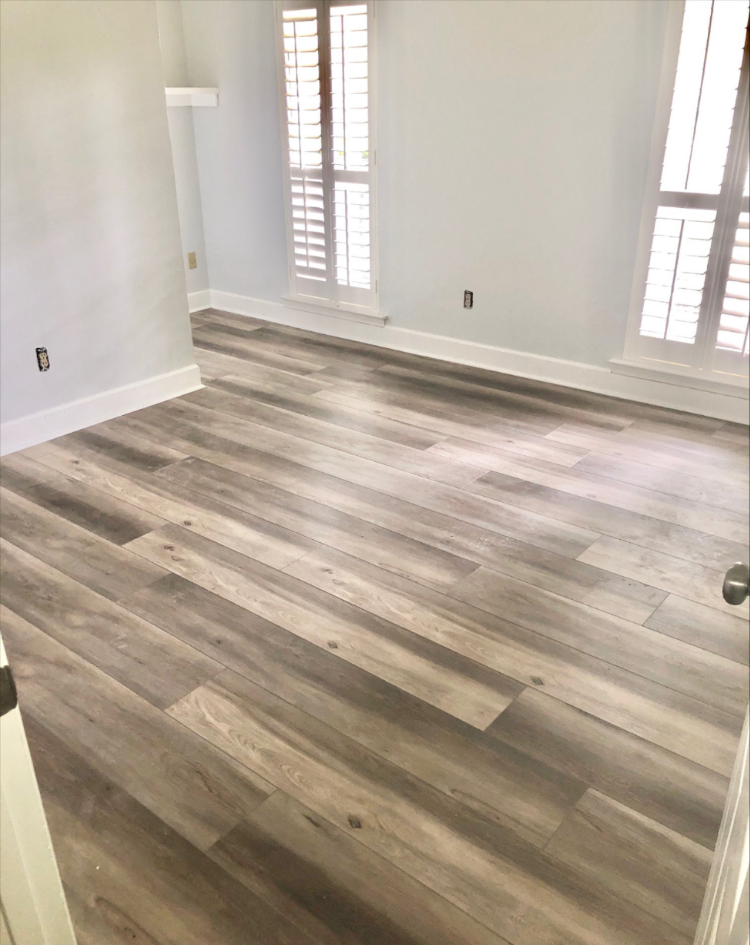 a room with vinyl wood floor and windows
