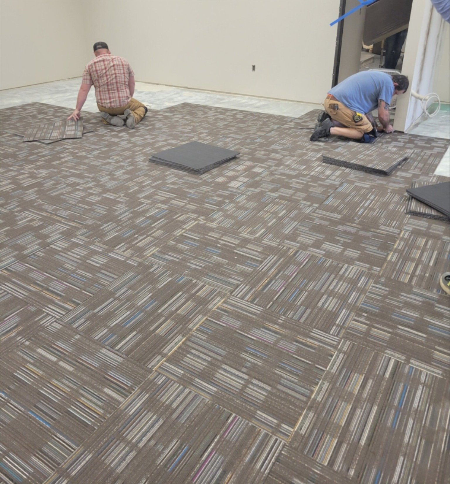 Local flooring professionals installing carpet tiles in Sallisaw, OK – Quality Floors team at work