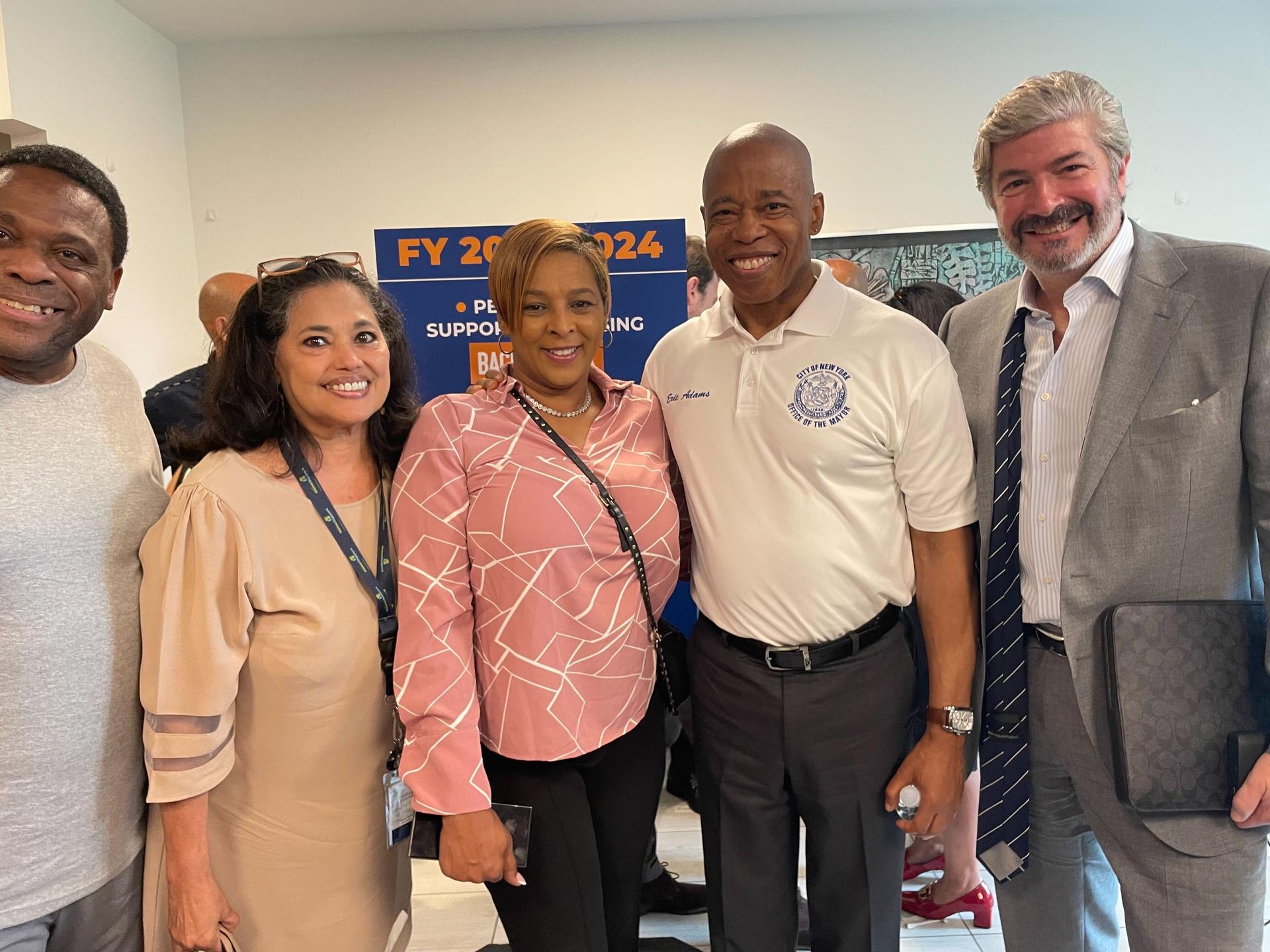 Mayor Eric Adams stands with four other people at an event