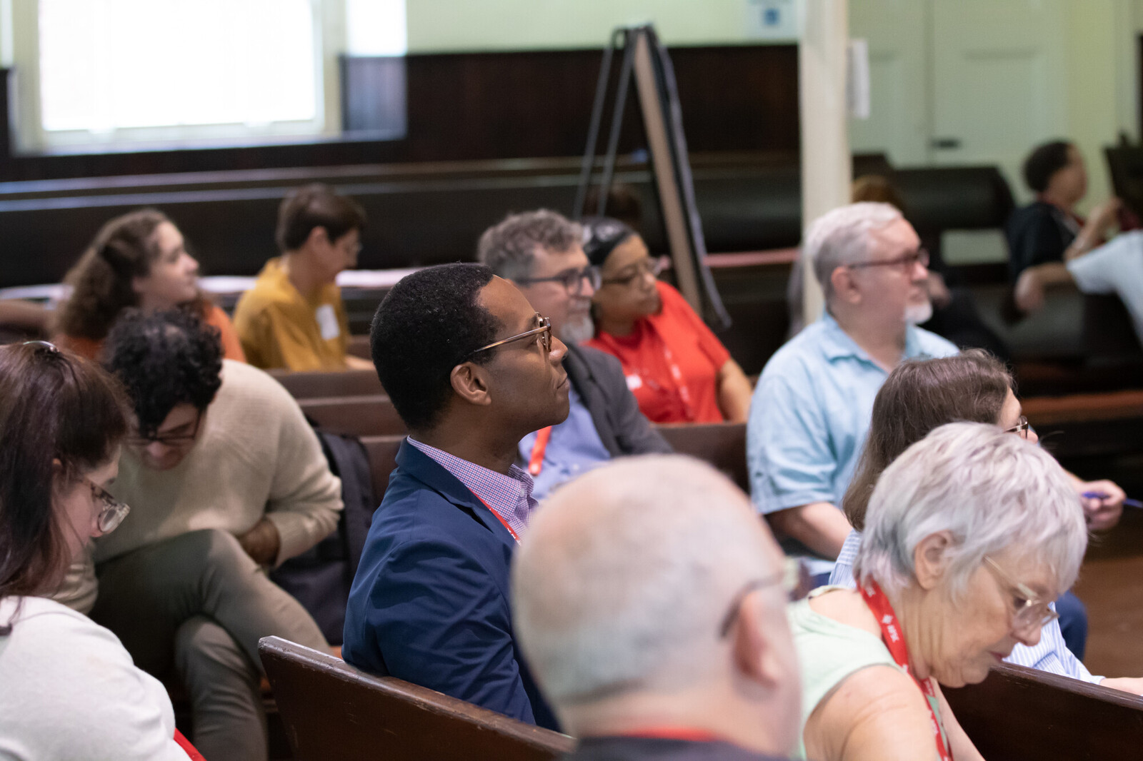 A picture of a group of people sitting together in a Meeting House. 