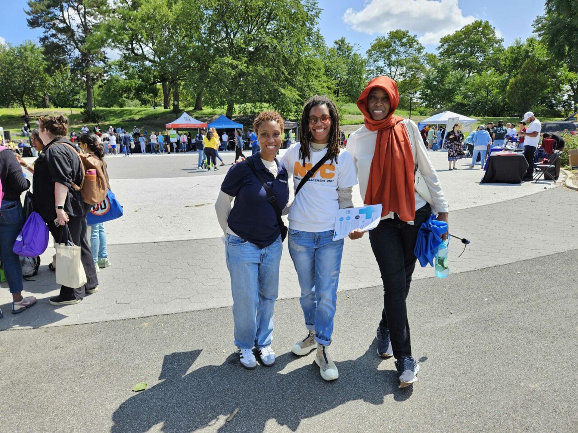 Photo of 3 P E U members posing together at a community event outside