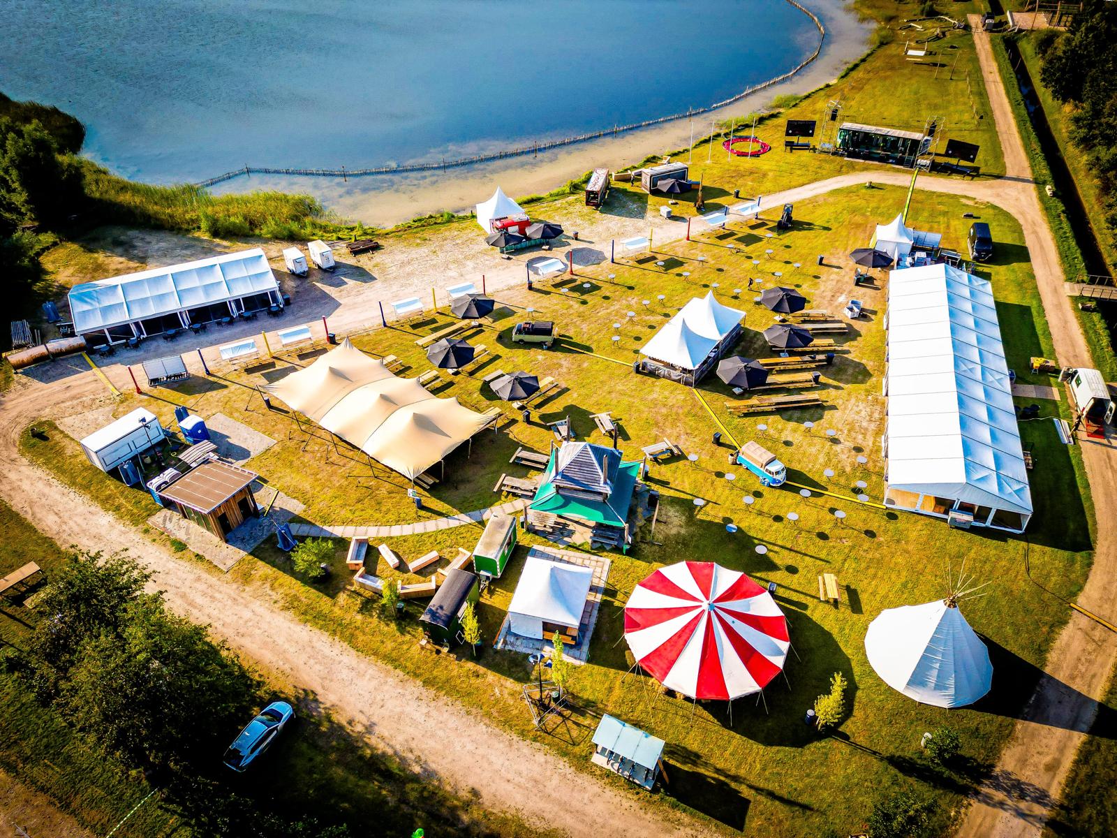 Een camper staat naast een overdekt terras op camperplaats De Stronk