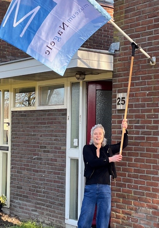 De vlag van Museum Nagele wordt gehesen bij de tijdelijke expositielocatie aan de Karwijhof 25