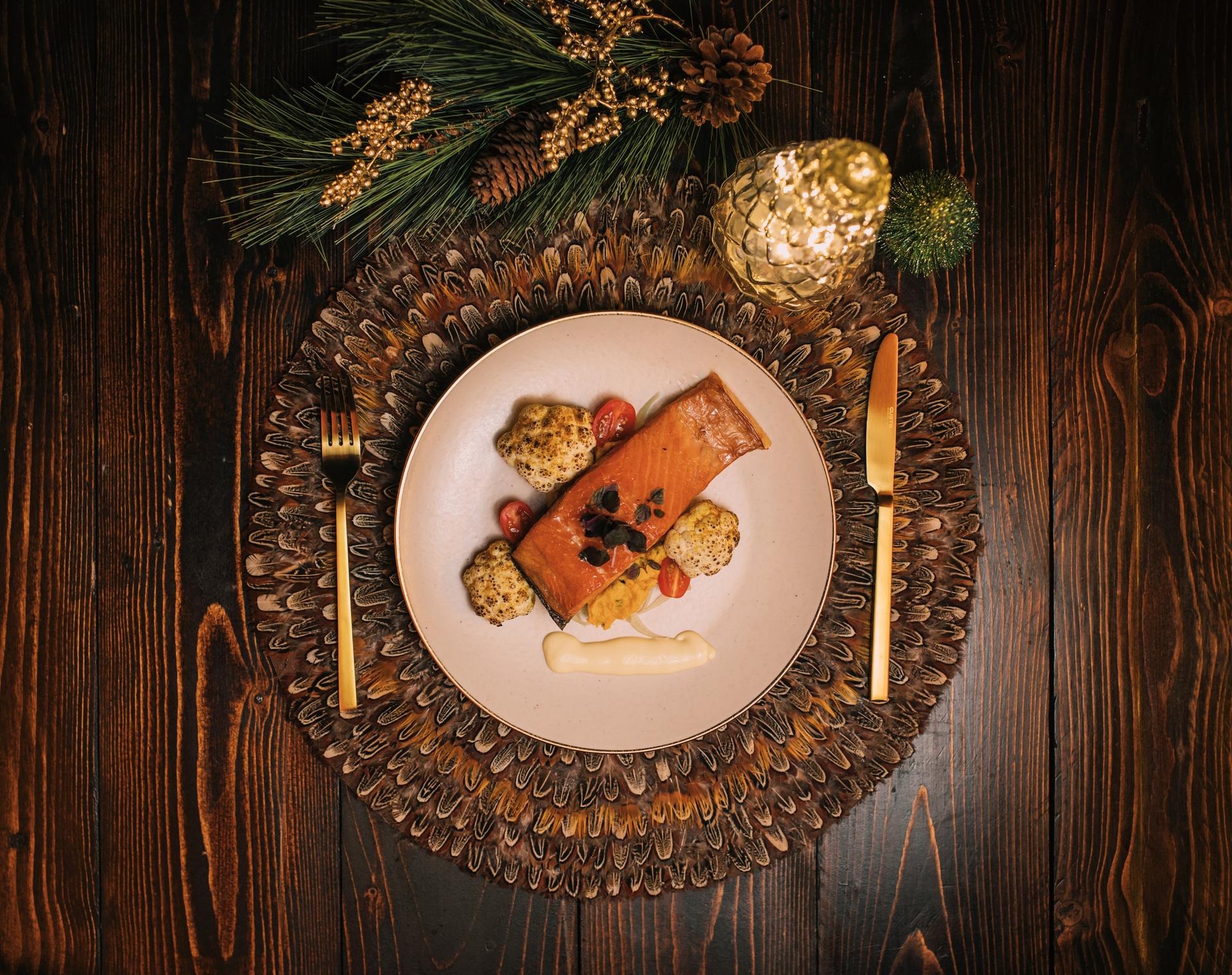 Een feestelijk aangekleed bord en tafel met daarop een onderdeel van het kerstmenu