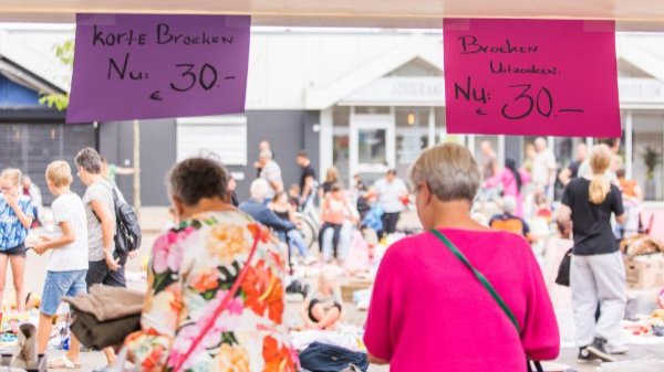 Twee bezoekers staan bij een kraam op de gezellige outlet van Emmeloord