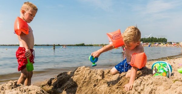 Twee kleine jongetjes spelen in het zand op het Schokkerstrand