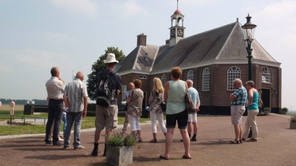 Een groep mensen volgt een rondleiding met gids door Museum Schokland