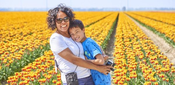 Een vrouw en haar zoontje laten zich voor een tulpenveld fotograferen
