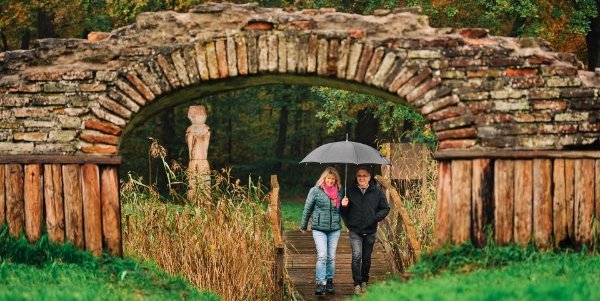 Een man en vrouw lopen met een paraplu op bij de Burcht van Kuinre
