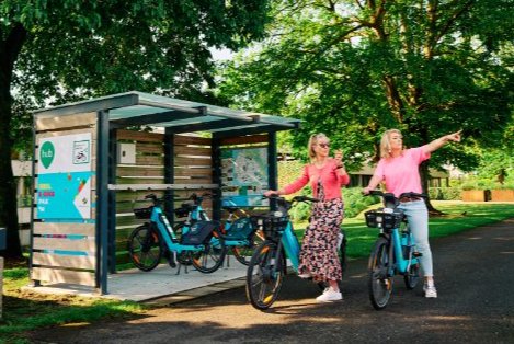 Twee vrouwen met e-bikes bij een deelfietshub 