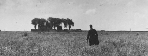 Zwart/wit-foto van een man die naar het pas op het droge belande voormalige eiland Schokland loopt