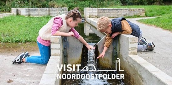 Twee kinderen spelen met een waterwerk in het Waterloopbos