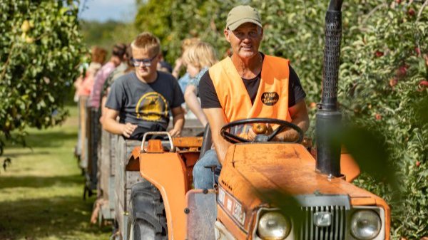 De plukbaar bestuurt de tractor waarmee kinderen in de pluktrein door de boomgaard van Vink Fruitboerderij worden gereden
