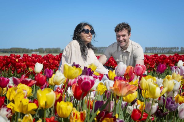Een man en vrouw poseren tussen de tulpen in het Tulpenbelevingsveld