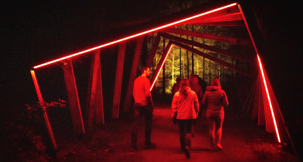 Bezoekers lopen in het donker de lichtpuntjesroute van Netl Park