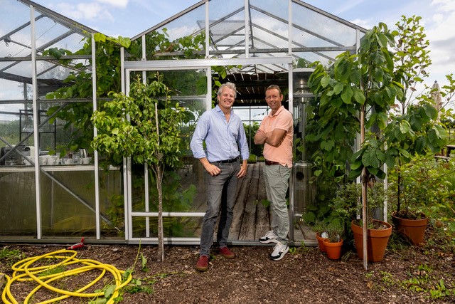 Jeroen Plesman en Carel Walhof poseren voor een kas.