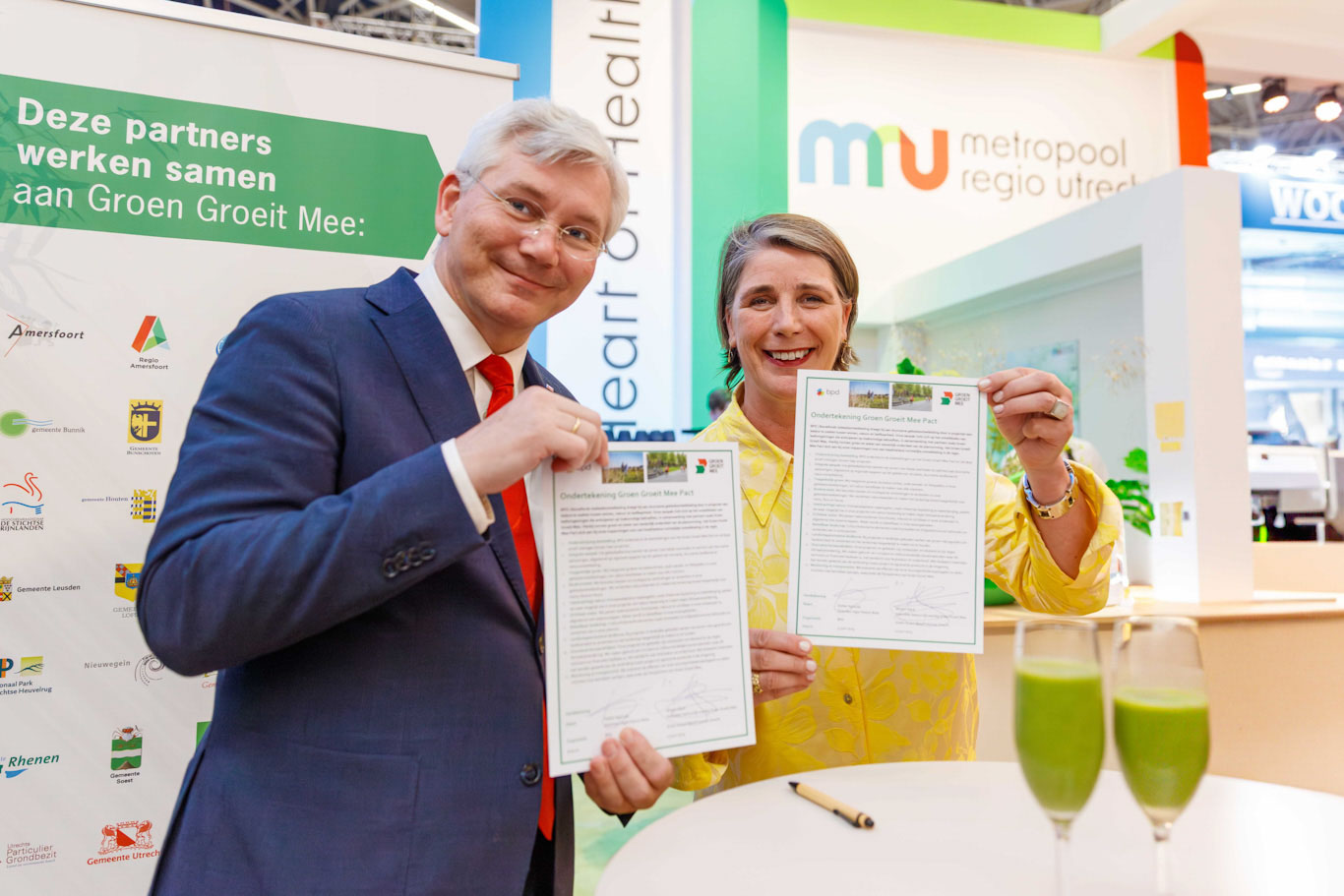 André van Schie en Esther Agricola laten trots het ondertekende Groen Groeit Mee Pact zien.