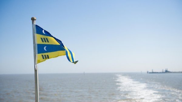 Waddenzee en vlag van Ameland op de veerboot