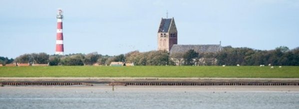 Vuurtoren en kerk in Hollum gezien vanaf de Waddenzee