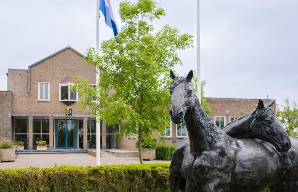Gemeentehuis van Ameland met beelden van paarden ervoor
