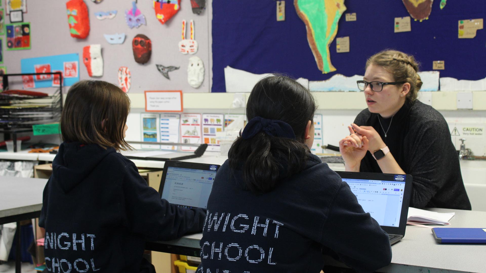 Mentor talking to two young students