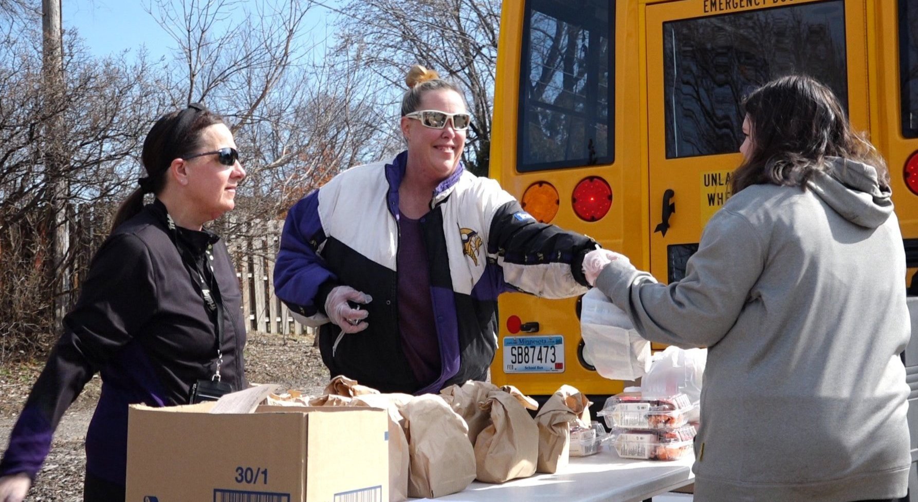 Nutritional Services staff handing out grab-and-go meals