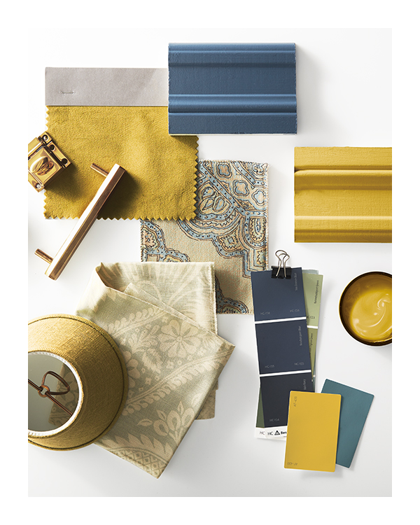 A flat lay featuring Benjamin Moore color chips, paint samples and a variety of linens in shades of navy and gold.