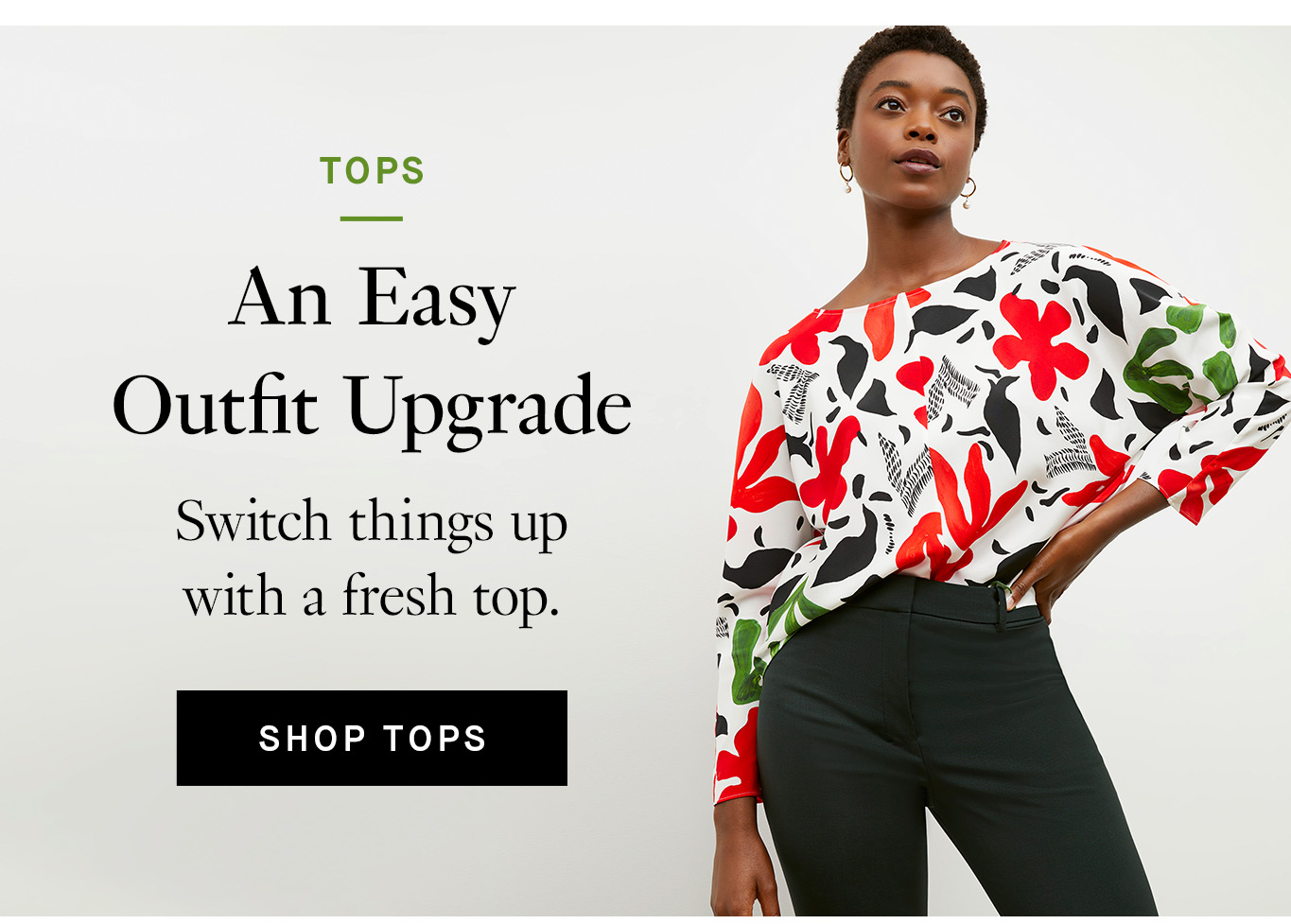 Image of a woman with short black hair standing against an off-white background with her left hand on her hip. She's wearing black pants and a long-sleeved, boatneck top that is white with a red, green, and black floral print. Black text overlay reads, ''An Easy Outfit Upgrade. Switch things up with a fresh top.'' A black button with white text reads, ''Shop Tops.''
