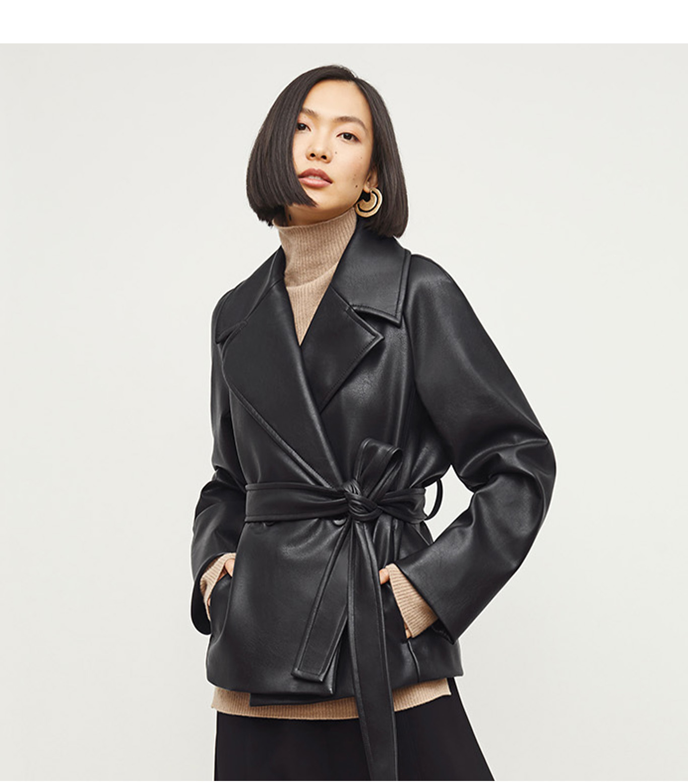 Woman wearing a beige turtleneck and black leather jacket