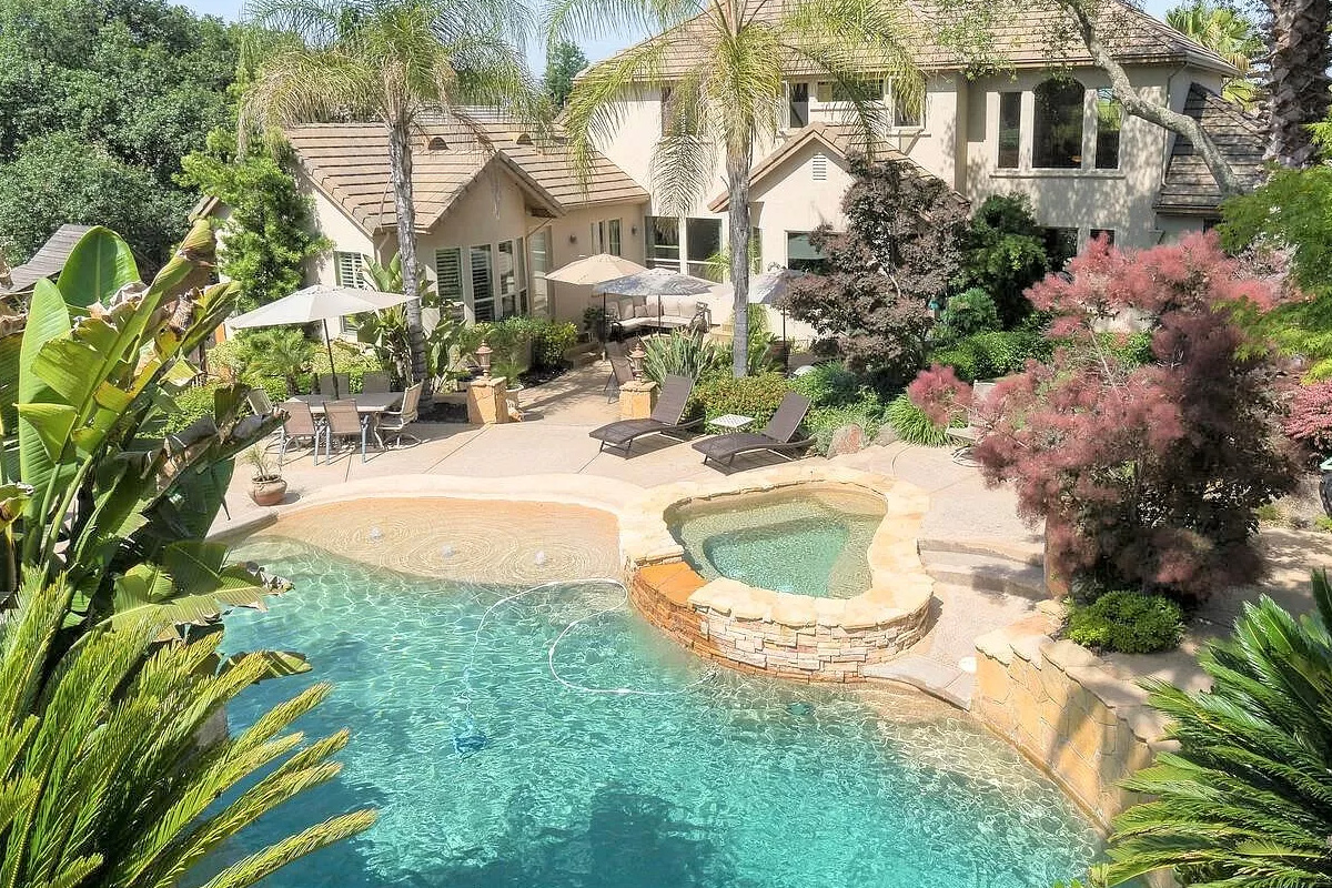 backyard with large pool and palm trees