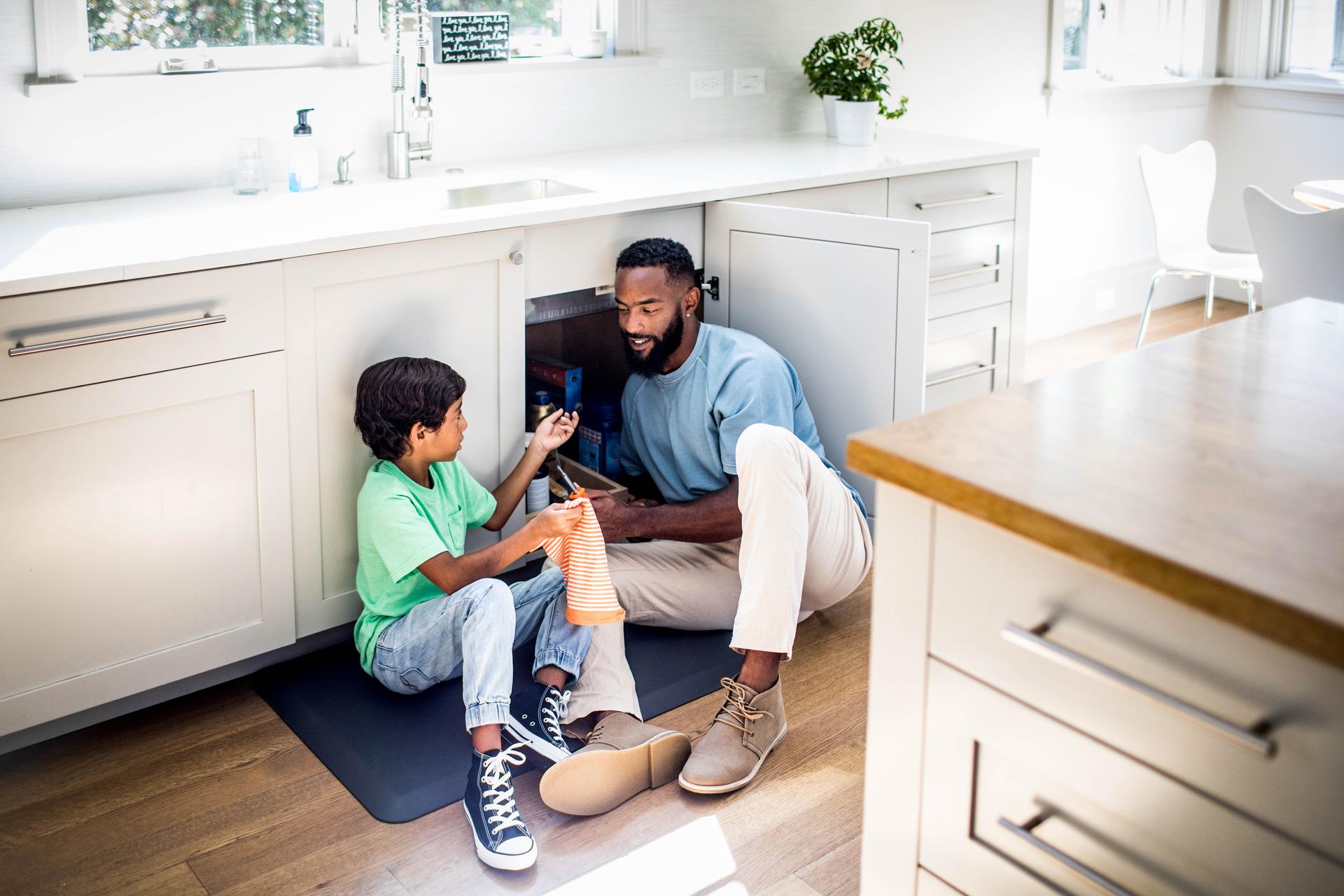 Dad and son fixing the kitchen sink