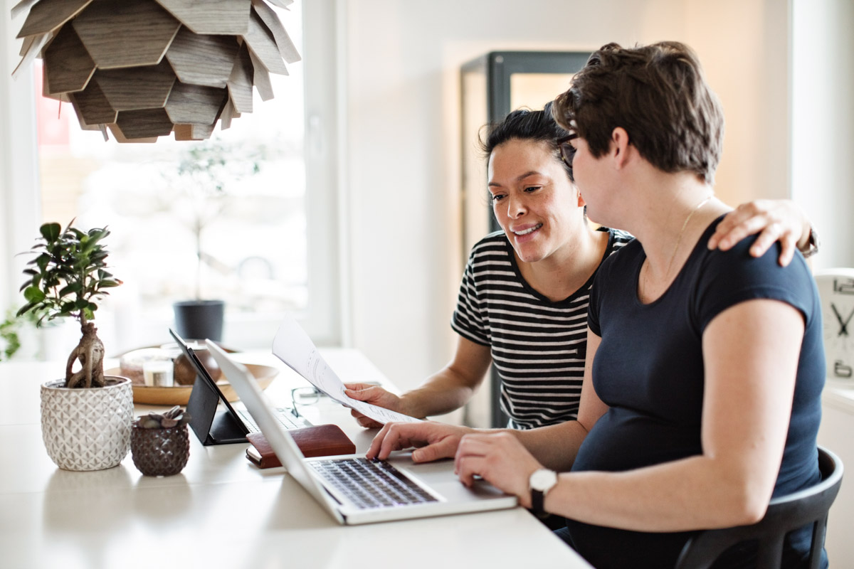 Two people at their kitchen counter working on their laptop