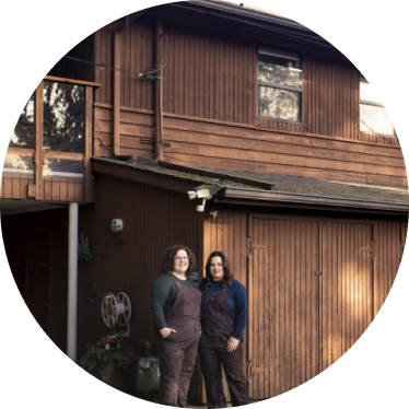 two people in front of brown house